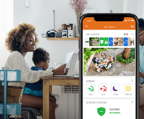 Parent using a smart home app on a smartphone while sitting at a table with a child